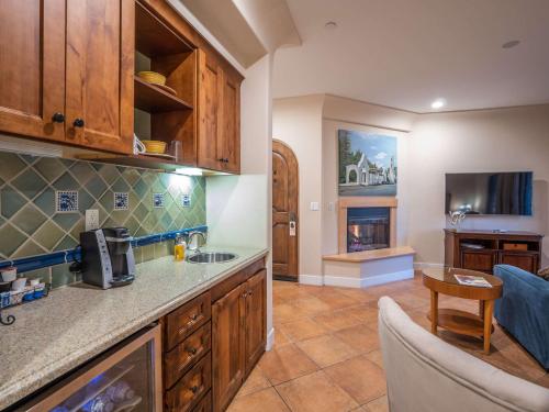 a kitchen with wooden cabinets and a living room at Su Nido Inn in Ojai