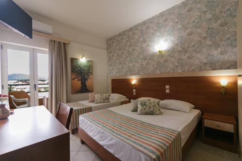 a hotel room with two beds and a balcony at Erato Hotel in Kokkini Khanion