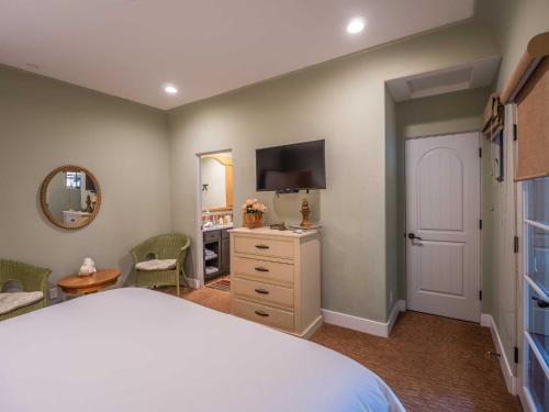 a bedroom with a bed and a dresser and a mirror at Su Nido Inn in Ojai