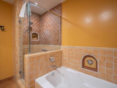 a bathroom with a bath tub with a shower and a sink at Su Nido Inn in Ojai