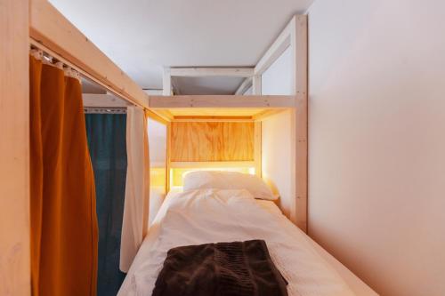 a small bed in a small room with a window at Montagu Hostel in Innsbruck