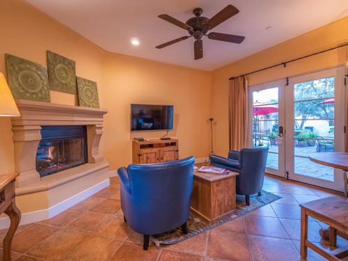 a living room with a fireplace and blue chairs at Su Nido Inn in Ojai