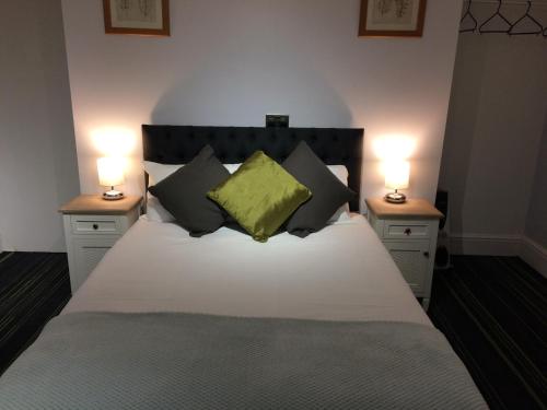 a bedroom with a white bed with two lamps on tables at Queens Guesthouse Manchester in Manchester