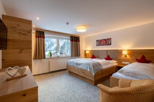 una camera d'albergo con due letti e una sedia di Appartement Schattauer a Wagrain