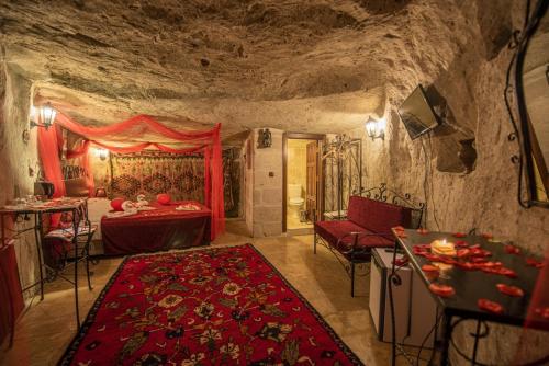 a bedroom in a cave with a bed and a table at Kapadokya Ihlara Konaklari & Caves in Guzelyurt