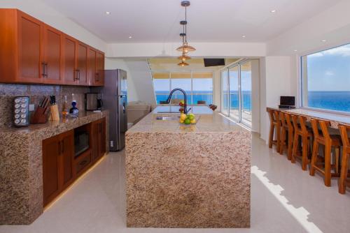 a kitchen with a island with a view of the ocean at 2 Story Oceanfront Penthouses on Cancun Beach! in Cancún