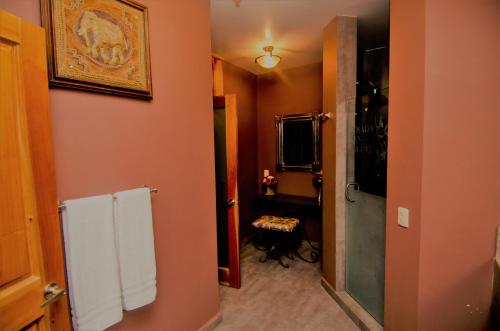 a bathroom with orange walls and white towels at Hotel Posada San Miguel in Jerez de García Salinas
