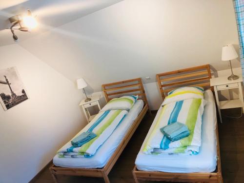 2 Betten in einem kleinen Zimmer mit 2 Lampen in der Unterkunft Ferienhaus Jehle Friedrichshafen in Friedrichshafen