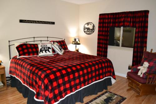 um quarto com uma cama com um cobertor xadrez vermelho e preto em River Place Condos #407 2BD em Pigeon Forge