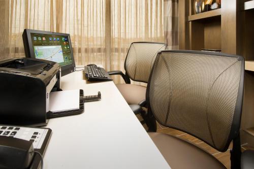 an office with a desk with a computer and chairs at Holiday Inn Express Boston North-Woburn by IHG in Woburn