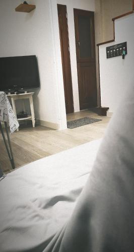 a bedroom with a bed and a tv and a door at Hôte "Il était une fois" in Hesdin