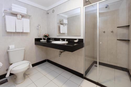 y baño con aseo, lavabo y ducha. en Hotel Bahia do Sol en Salvador
