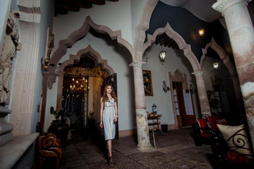 a woman in a dress standing in a hallway at Hotel Posada San Miguel in Jerez de García Salinas