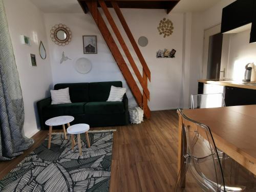 sala de estar con sofá verde y mesa en Au Coeur des Rousses, en Les Rousses