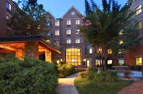 a large building with a tree in front of it at Staybridge Suites Tysons - McLean by IHG in McLean