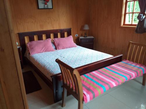 a bedroom with a bed and a bench in it at Villa Rosa House in Pinto