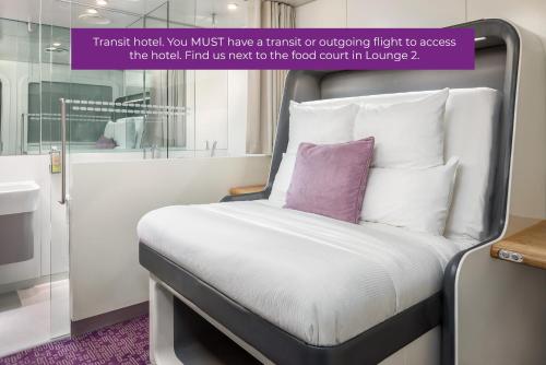 a white bed with pillows and pillows in a room at YOTELAIR Amsterdam Schiphol Transit Hotel in Schiphol