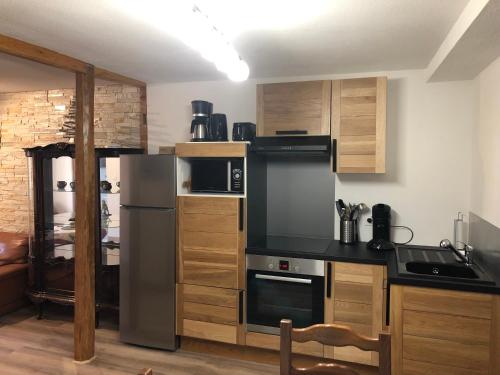Una cocina con refrigerador de acero inoxidable y gabinetes de madera. en Gîte de l'Est 1, en Colmar