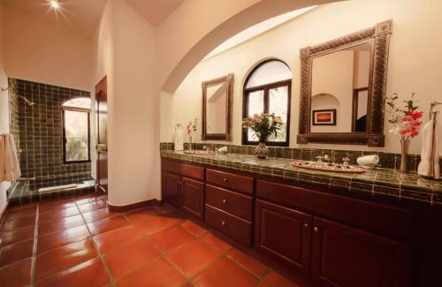 een grote badkamer met 2 wastafels en 2 spiegels bij Hacienda Todos Los Santos in Todos Santos