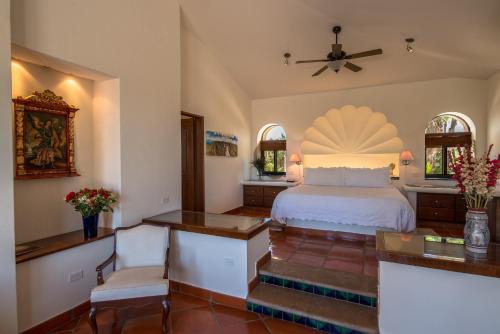 a bedroom with a bed and a desk and chairs at Hacienda Todos Los Santos in Todos Santos