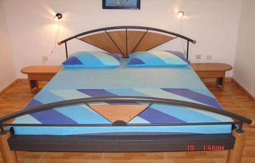 - une chambre avec un lit et une couette bleue dans l'établissement Apartments Dijana - economy apartments, à Sveta Nedelja