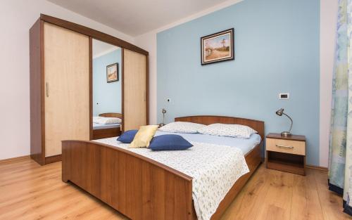 um quarto com uma cama grande e almofadas azuis em Apartments Vola em Vrbnik