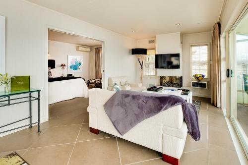 a living room with a couch and a bed at On The Point - Lake Rotorua in Rotorua