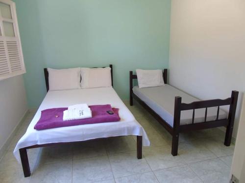 a bed and a chair in a room at Pousada Dona Maria in Areias