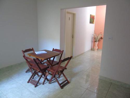 a dining room with a wooden table and chairs at Pousada Dona Maria in Areias