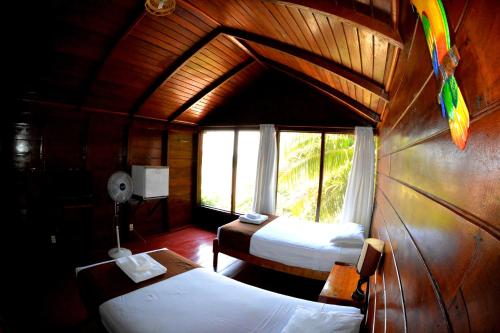 a room with two beds and a window at Wasai Puerto Maldonado Eco Lodge in Puerto Maldonado