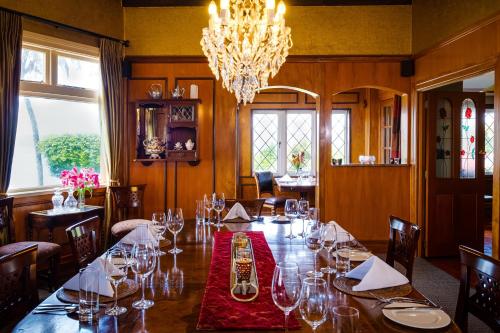 a dining room with a long table with wine glasses at On The Point - Lake Rotorua in Rotorua