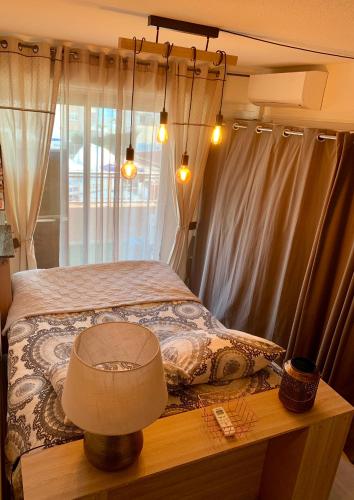 une chambre avec un lit et une table avec une lampe dans l'établissement Cocoon vue Mer ☆ en face du Port de Golfe-Juan ☆, au Golfe-Juan