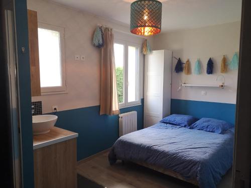 a bedroom with a bed and a bathroom with a sink at Holiday Home Maison de l'Océan à Denneville in Denneville