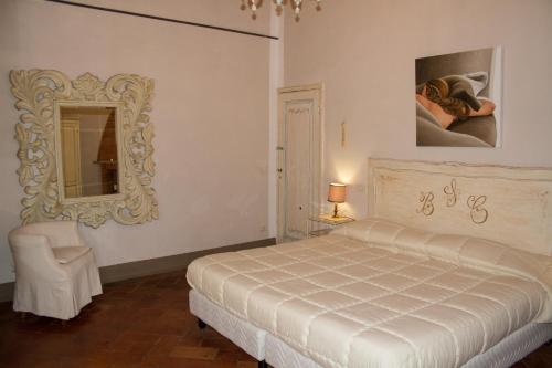 una camera con letto, specchio e sedia di Santa Croce Charme Apartment ad Arezzo