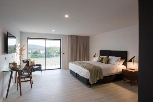 a bedroom with a bed and a table with a chair at The Seabird in Moruya