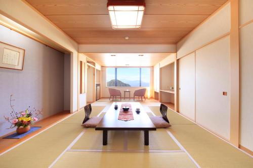a conference room with a table and chairs and a large window at Hotel Tsubakino in Yamanouchi