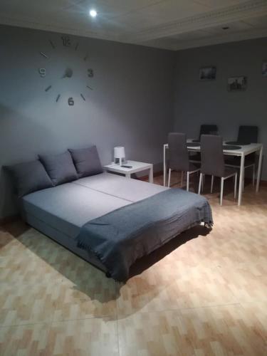 a bedroom with a bed and a clock on the wall at Casa De Paz in Zamora