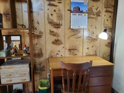 a desk with a chair in a room with a wall at Little River Inn Motel in Leon
