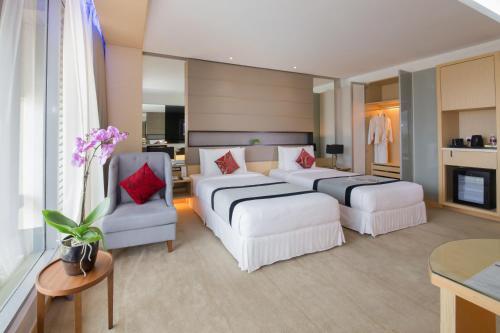 a hotel room with two beds and a living room at Ancasa Royale, Pekan Pahang in Pekan