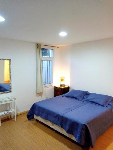 a bedroom with a blue bed and a window at Garden Atelier Eco Friendly in La Cumbre