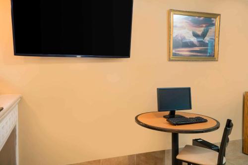 a small table with a computer on a wall at Travelodge by Wyndham Santee in Santee