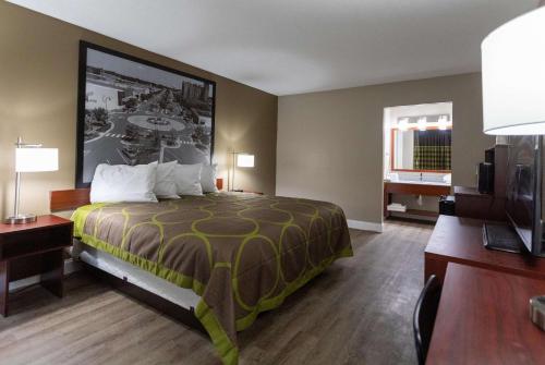 a hotel room with a bed and a flat screen tv at Super 8 by Wyndham Goldsboro in Goldsboro