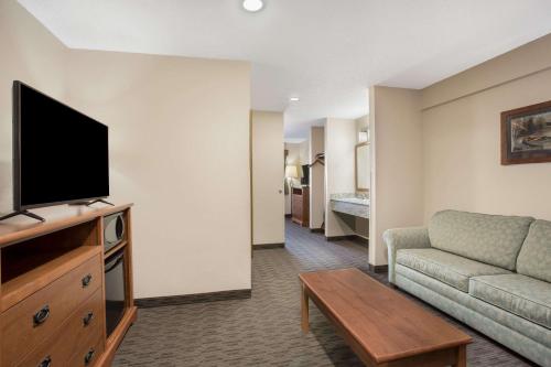 a living room with a couch and a flat screen tv at AmericInn by Wyndham Sioux City in Sioux City