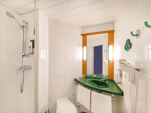 een badkamer met een douche, een wastafel en een toilet bij Ibis Praha Mala Strana in Praag