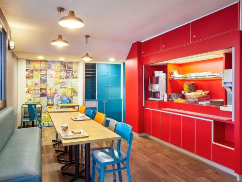 a dining room with red cabinets and a table and chairs at hotelF1 Lyon Gerland Vénissieux in Vénissieux