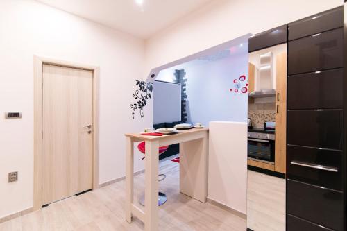 a kitchen with a table and a black refrigerator at Data Central Studio in Novi Sad