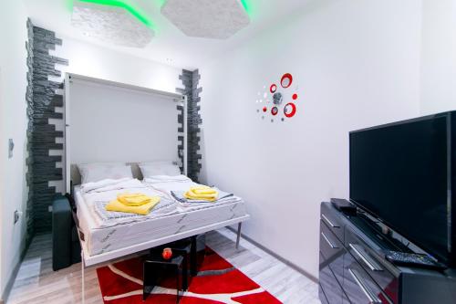a white room with a bed and a tv at Data Central Studio in Novi Sad