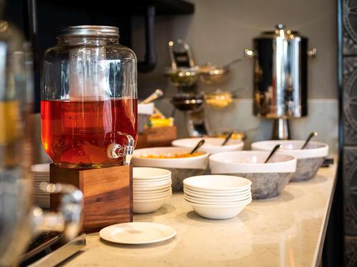 a counter with bowls and plates and a jar of food at Mercure Bridgwater in Bridgwater
