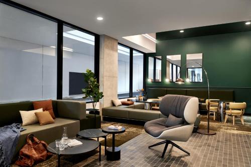 a living room with a couch and a table at Veriu Green Square in Sydney