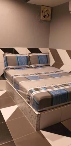 a large bed in a room with a tiled floor at Benjamas hostels in Bangkok